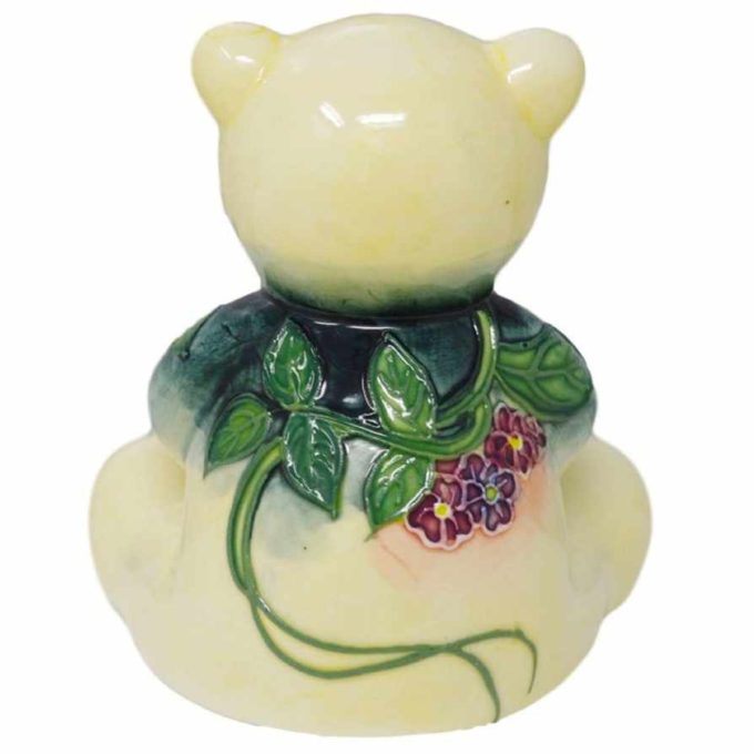 Small figurine of a teddy bear ornament with purple and pink flower design tube lined pottery