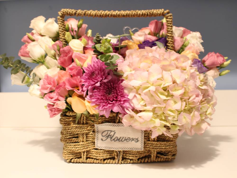 a basket full of pretty flowers, pink roses, white coronations make a lovely present for grandmothers